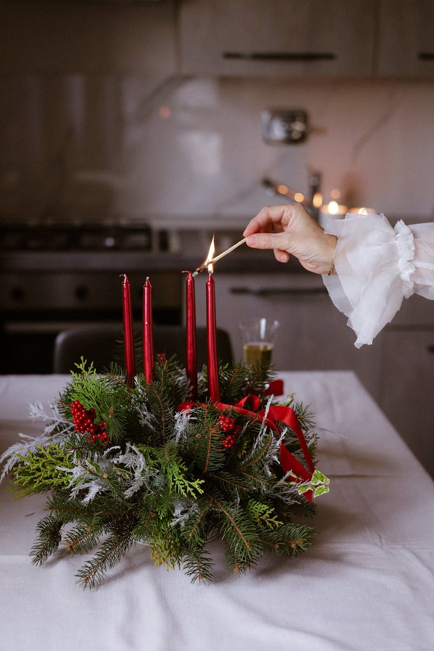 elegant holiday candle lighting with festive arrangement